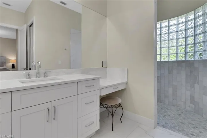 Bathroom with vanities, make up area  and a walk in shower