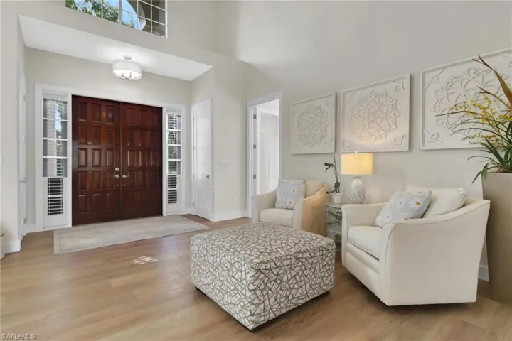 Foyer entrance with plenty of natural light, wood finished floors, and a high ceiling