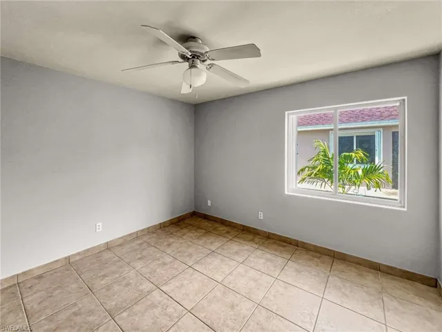 Room featuring neutral wall tones, square tile flooring, and a ceiling fan with integrated lighting