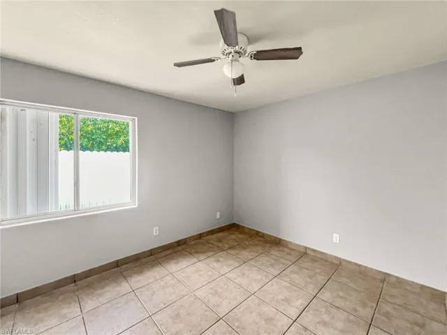 Room featuring light-toned walls and square tile flooring