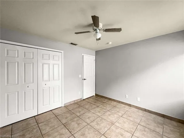 Interior room featuring light gray walls and square tile flooring