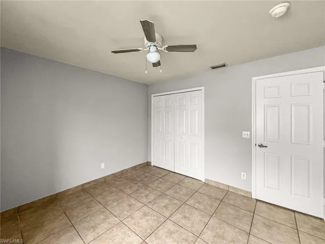 Room with neutral-toned tile flooring, light gray walls, and white trim