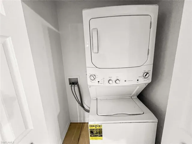 White stackable washer and dryer unit with top-loading washer and front-loading dryer