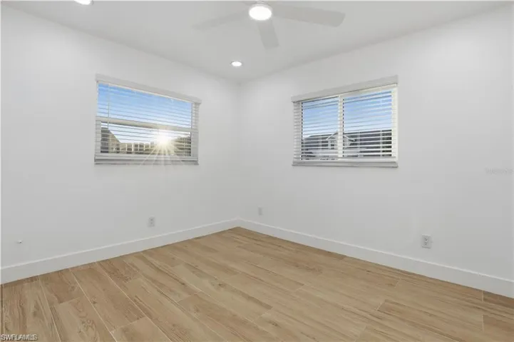 Empty room featuring light wood-style flooring, a ceiling fan, and recessed lighting