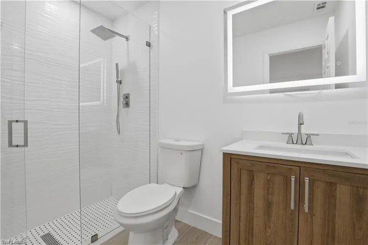 Bathroom featuring vanity, a stall shower, and light wood finished floors