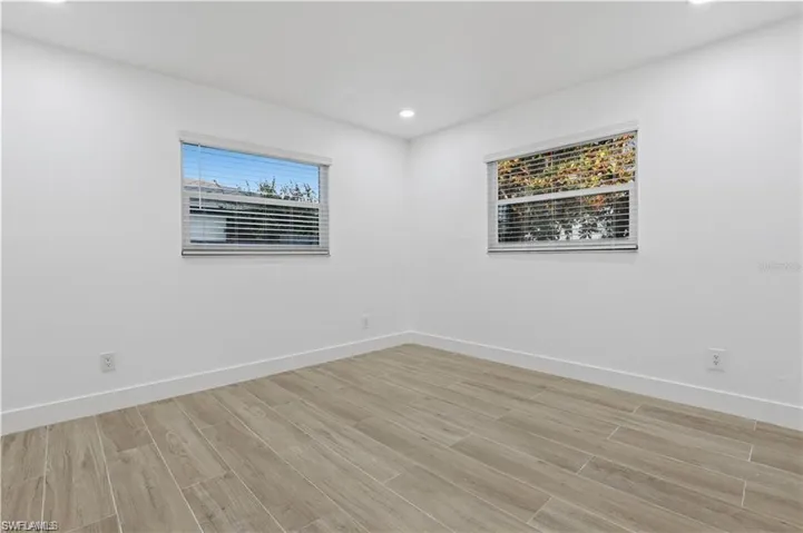 Spare room with wood finish floors and recessed lighting