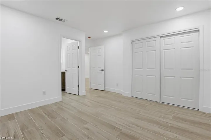Unfurnished bedroom featuring light wood-type flooring, a closet, and recessed lighting