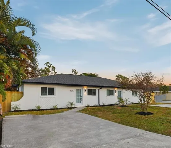 Ranch-style house with stucco siding and roof with shingles