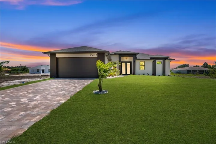 Contemporary single-story residence featuring a dark asphalt shingle roof and light-colored stucco exterior