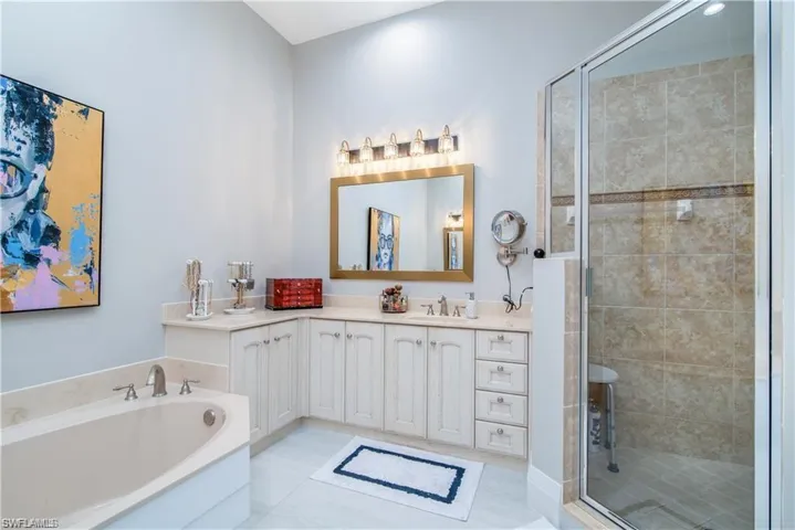 Bathroom with vanity, a garden tub, and a stall shower