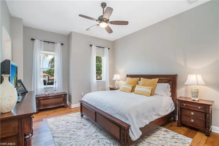Bedroom featuring multiple windows, light wood-style flooring, and a ceiling fan