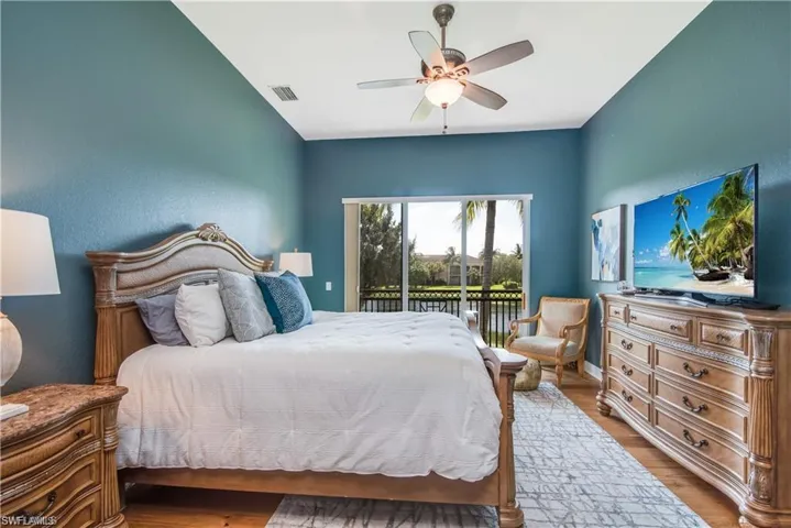 Bedroom with access to outside, wood finished floors, and a ceiling fan