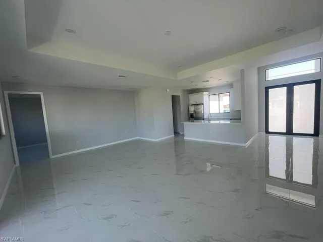 Unfurnished living room featuring a tray ceiling and sink