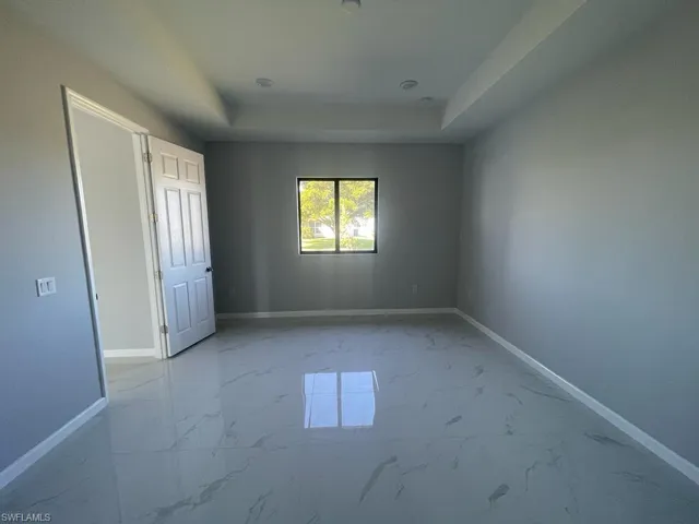 Unfurnished bedroom featuring a raised ceiling