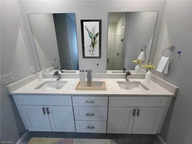 Primary Bathroom with a shower with shower door and vanity