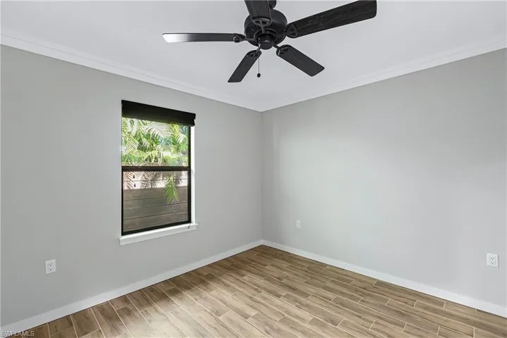 Unfurnished room with ceiling fan, light hardwood / wood-style floors, and crown molding
