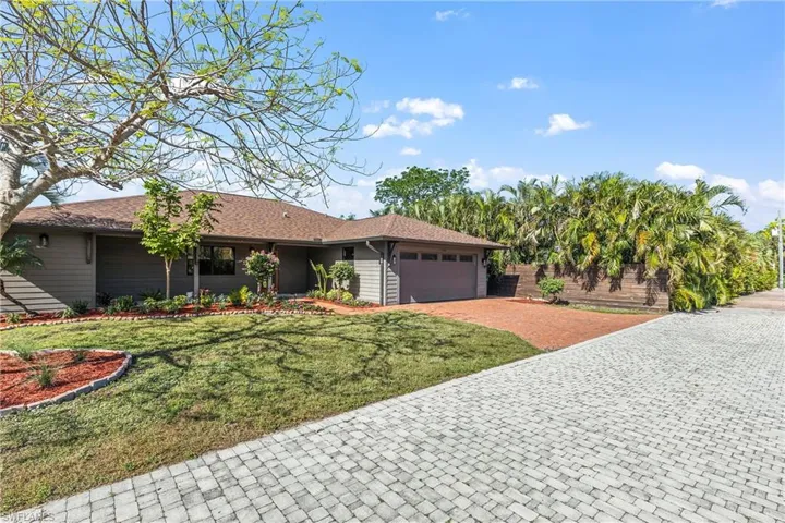 Single story home featuring a garage and a front lawn
