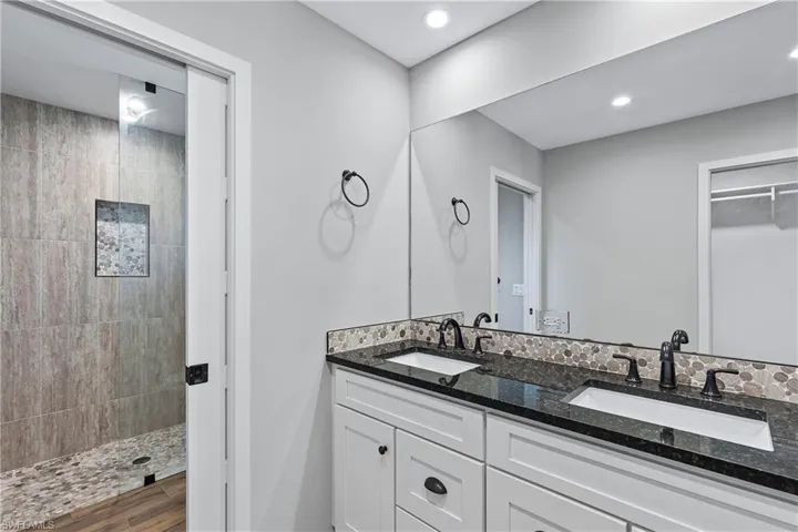 Bathroom featuring vanity, wood-type flooring, and tiled shower