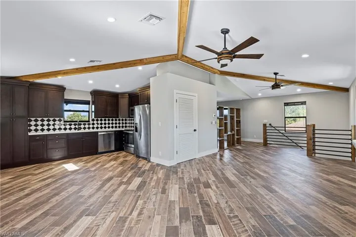 Kitchen with tasteful backsplash, ceiling fan, hardwood / wood-style floors, and stainless steel appliances