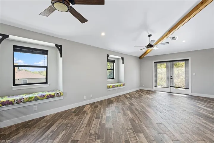 Empty room featuring ceiling fan, a healthy amount of sunlight, and hardwood / wood-style flooring