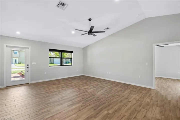 Unfurnished living room with vaulted ceiling, light hardwood / wood-style flooring, and ceiling fan