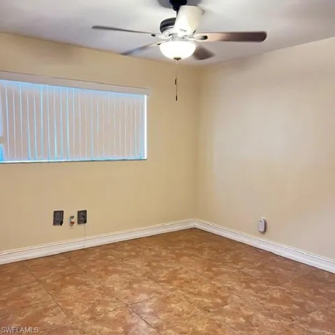 Room featuring patterned floor tiles, light-toned walls, and white baseboards