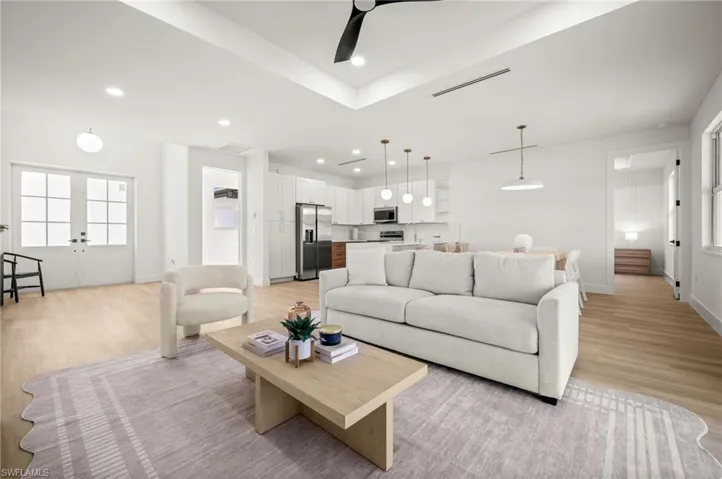 The open-concept living area features light-colored flooring, recessed lighting, and a contemporary ceiling fan