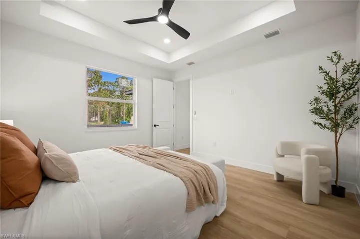 Bedroom featuring a tray ceiling, recessed lighting, and a modern ceiling fan