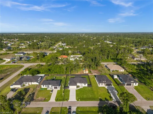 Aerial view of the property with a deep lot and a large front lawn, offering a spacious setting