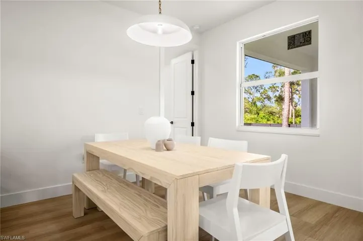 This room features light-toned wood style flooring and a window providing natural light and views of trees