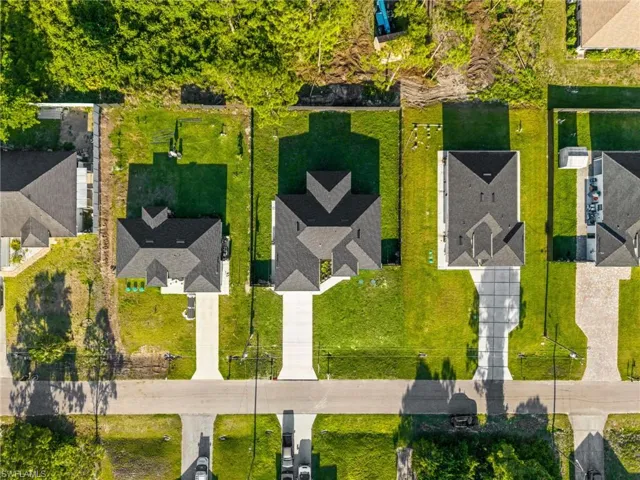 This property features a well-maintained lawn and a private driveway leading to the residence