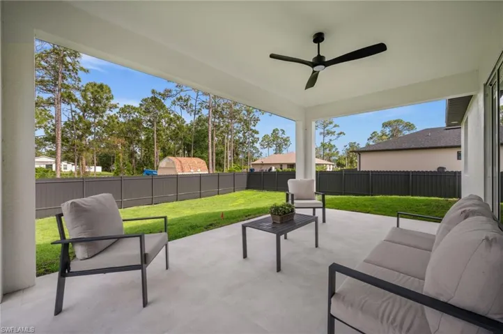 The property features a covered patio with a ceiling fan, offering an outdoor living space