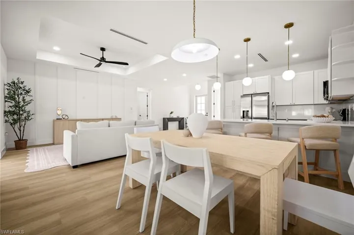 Open concept living area featuring light-toned wood style flooring, recessed lighting, and a modern ceiling fan