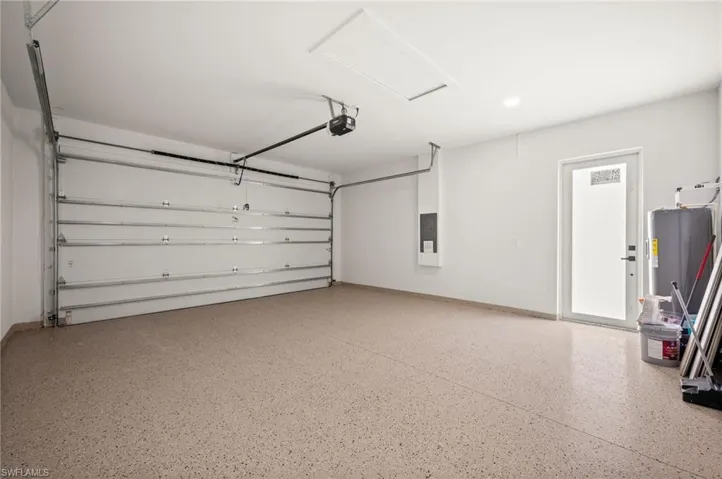 The garage features a coated epoxy floor, a white overhead garage door, and a white side door with a frosted glass panel