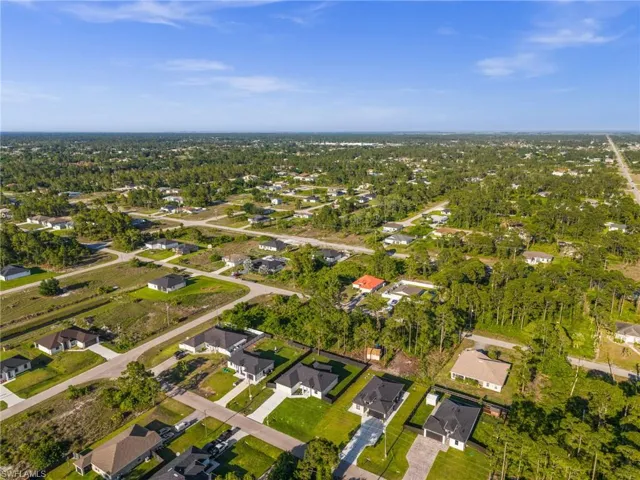 Aerial view of the surrounding neighborhood, featuring numerous properties with well-maintained lawns and mature trees