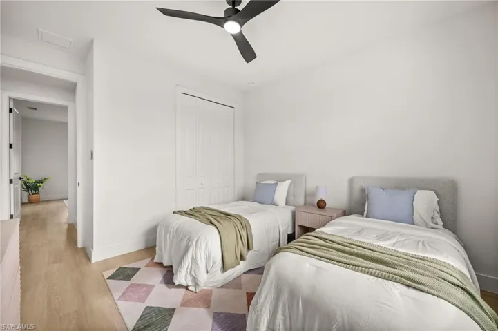 This room features light-colored walls, a ceiling fan, and light-toned wood style flooring