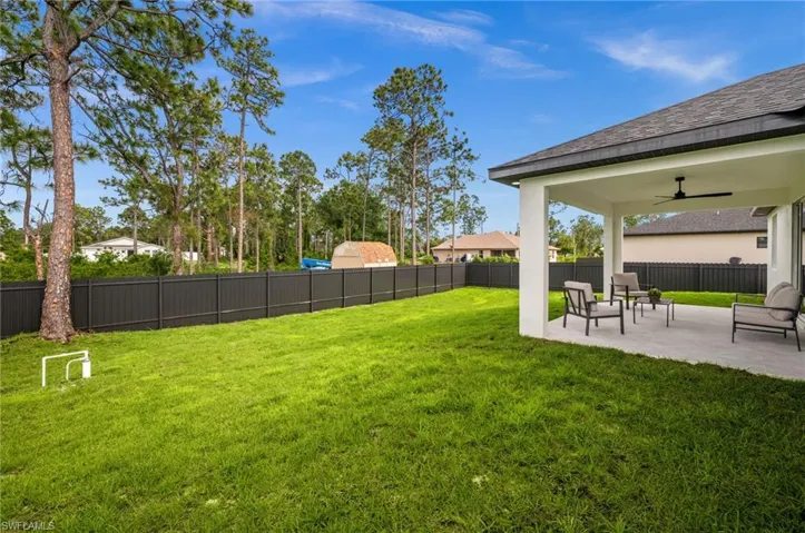 The property features a spacious rear yard with a well-maintained lawn and a privacy fence