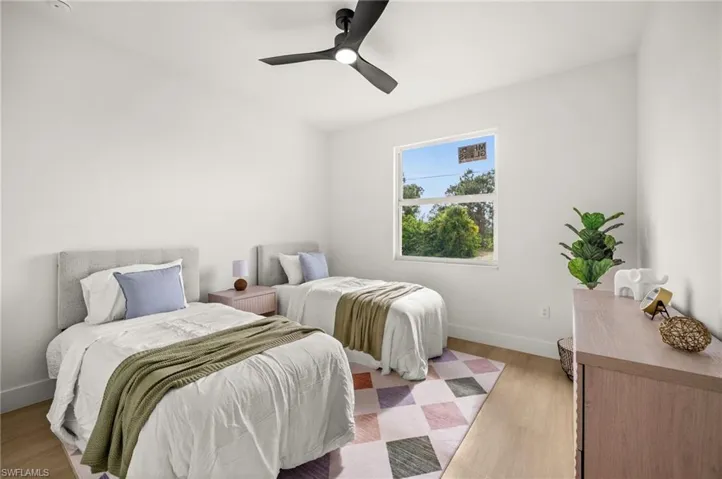 This room features light-toned wood style flooring, a window providing natural light, and a ceiling fan