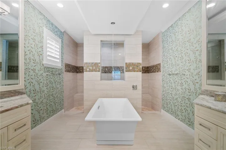 Free-standing tub with ceiling-mounted tub filler and glass shower wall insert