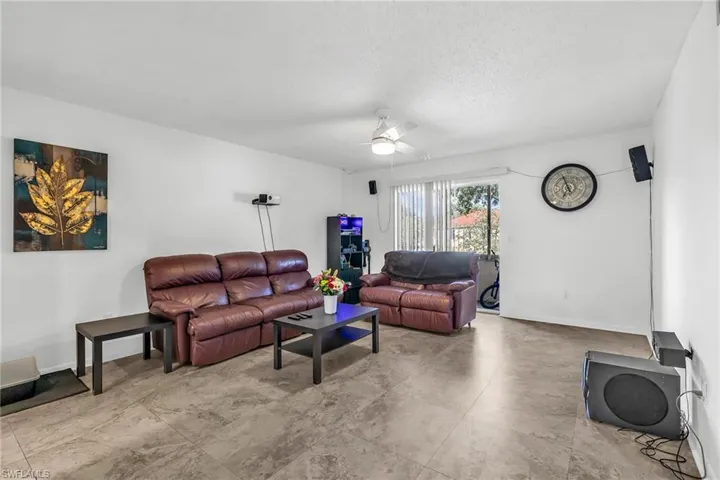 Living area featuring a ceiling fan and a textured ceiling