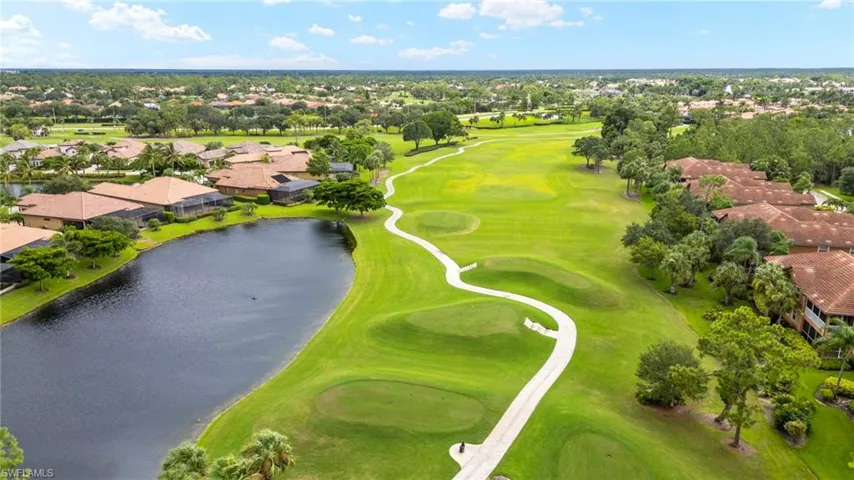 Aerial view of residential area featuring a golf club and a nearby body of water