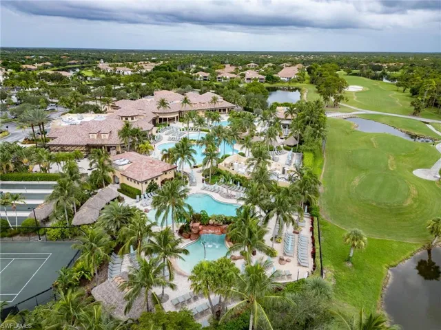 Aerial view of property and surrounding area featuring a nearby body of water and a golf club
