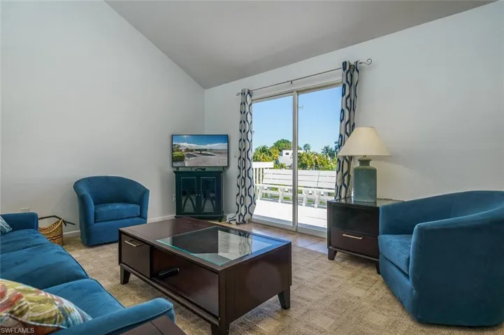 Living room featuring vaulted ceiling and carpet