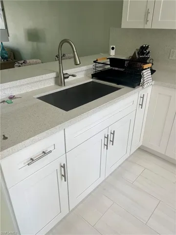 Kitchen featuring white cabinets and light stone countertops