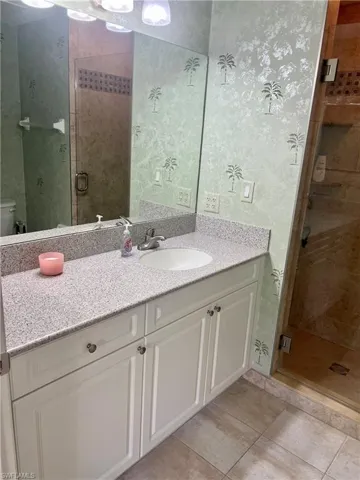 Full bath featuring vanity, a shower stall, and tile patterned floors