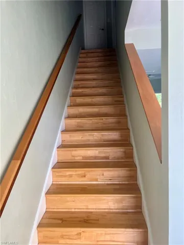 Stairway featuring hardwood / wood-style flooring