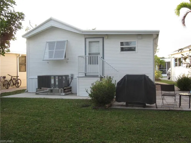 Rear view of property featuring a patio and a lawn