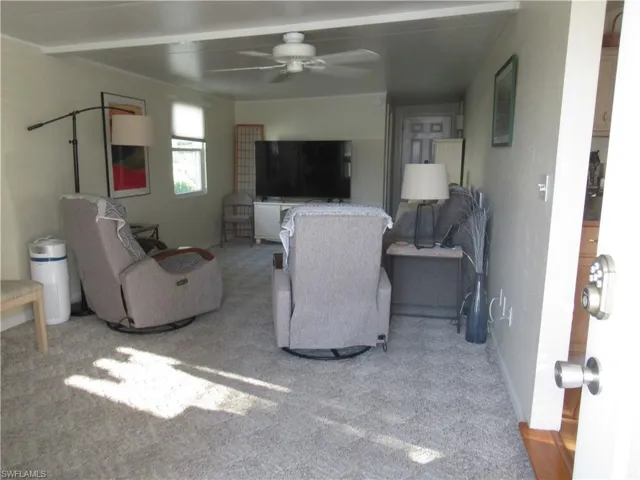 Living room featuring a ceiling fan and light carpet