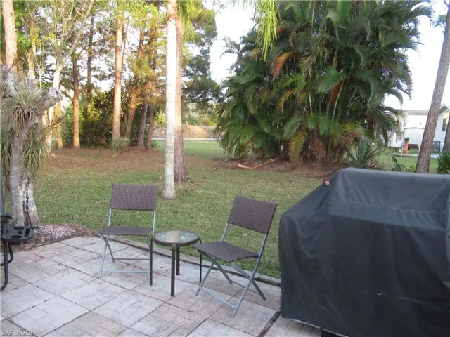 View of green lawn with a patio area