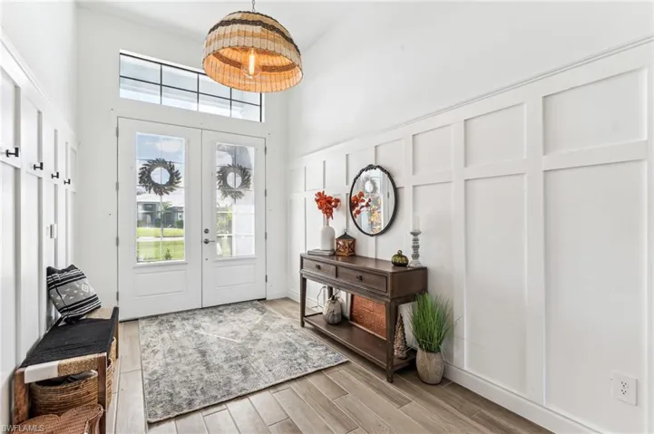 Entrance foyer featuring french doors, a wealth of natural light, and light wood-type flooring